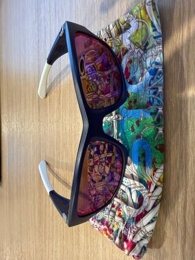 Oakley sunglasses with matte navy frame. Lenses show red mirror tint.